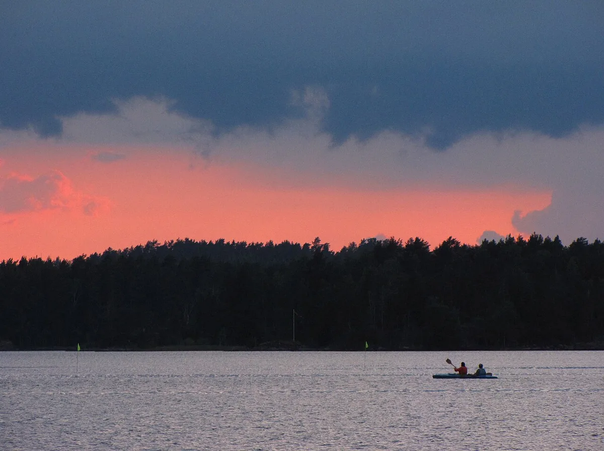 Kanootti järvellä auringonlaskussa